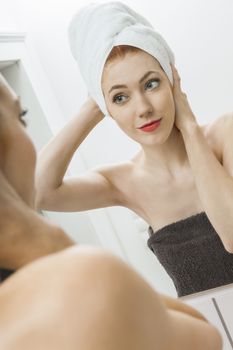 Close up Fresh Young Woman From Shower Looking her Face While Touching it In Front the Mirror