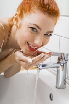 Close up Happy Young Woman Washing her Face While Looking at the Camera for a Moment.