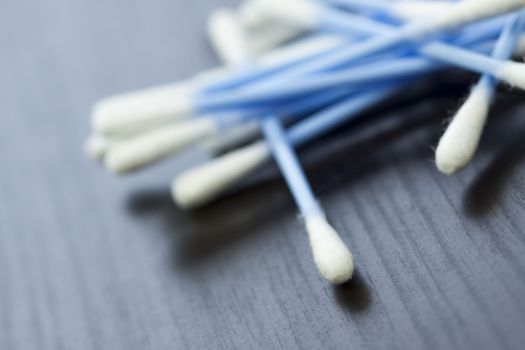 Random pile of blue plastic cotton ear buds for cleaning wax out of the ear in a health and hygiene concept