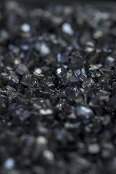 Background texture of an asphalt or tarmac road surface showing the tiny stones in the gravel with shallow dof