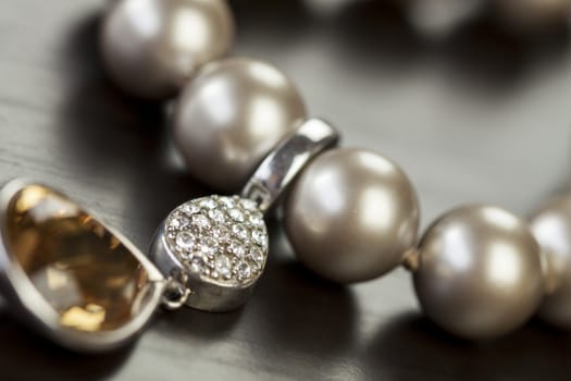 String of shiny grey beads winding through the frame in a close up view of fashion jewellery with selective focus to two beads