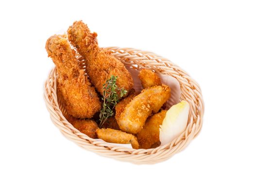 Crisp crunchy golden chicken legs and wings deep fried in bread crumbs and served with a bowl of dip in a wicker basket for a delicious appetizer