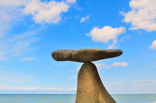 Balance of pebble on the top of triangular stone