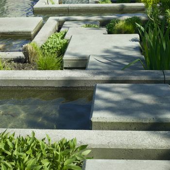 Urban garden water feature of concrete and vegetation