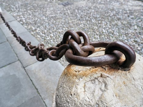 Old anchored iron chain on the ground