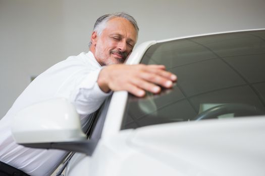 Man hugging on a car at new car showroom