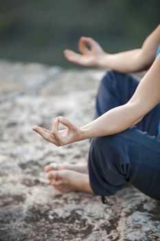 Close up of female hand zen gesturing. Girl sits in asana position