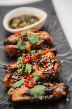 Hot organic chicken wings with red pepper on black dish