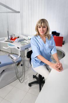 dentist office interior, female doctor sitting at the table