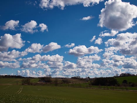 Green field and blue sky with clouds nature background