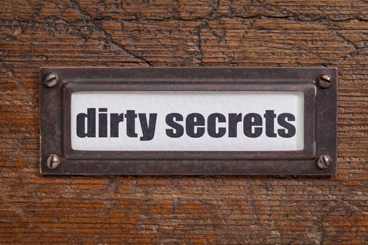 dirty secrets  - file cabinet label, bronze holder against grunge and scratched wood