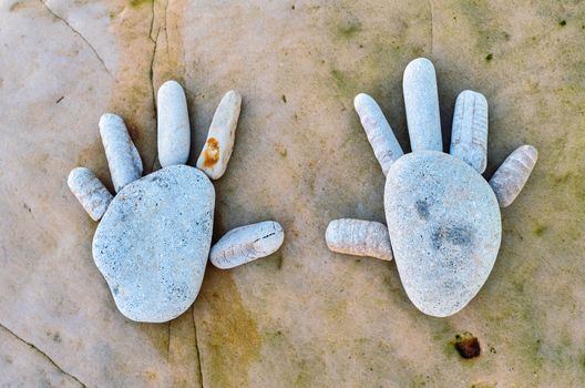 Hand trace of pebbles on the sea boulder