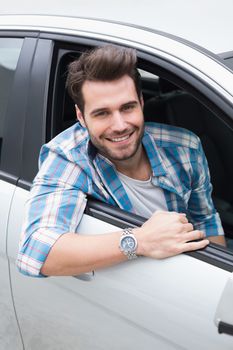 Young man smiling at camera in his car