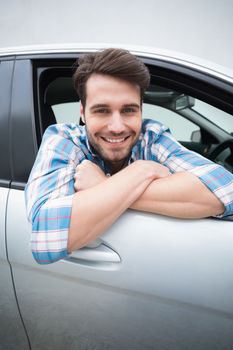 Young man smiling at camera in his car