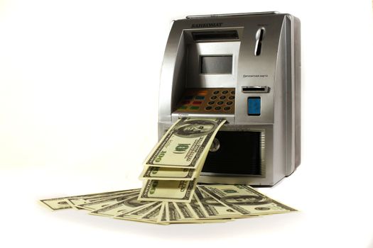 Piggy bank in the form of an ATM with hundred dollar banknotes