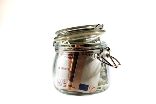 Glass jar filled with banknotes of different countries