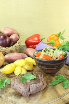 Ostrich steaks with baked potatoes on a wooden board