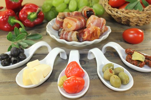 Tapas stuffed with prunes, figs, apricots and bacon on wooden background