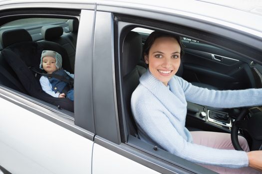 Mother driving with her baby in the car seat in her car