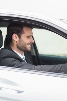 Happy businessman in the drivers seat in his car