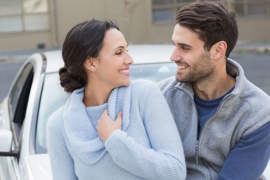 Young couple smiling at each other outside their car