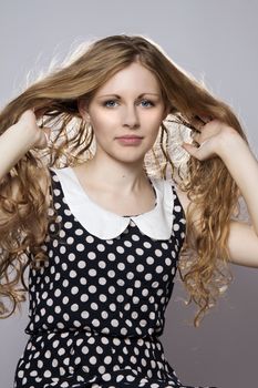 Young long-haired curly blonde woman presented beautiful natural long curly blond hair