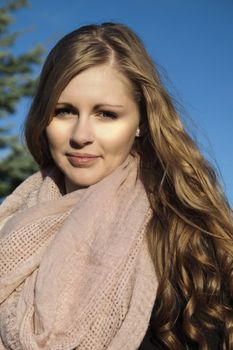 Young long-haired curly blonde woman presented beautiful natural long curly blond hair