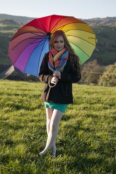 Young long-haired curly blonde woman with its colorful large umbrella