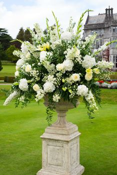 urn of opulent bouquet of flowers in manor gardens