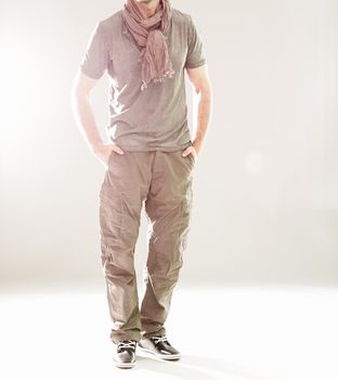 Elegant young handsome man in gray clothing. Studio fashion portrait.