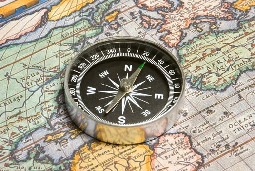 Round compass and ancient map (close up).