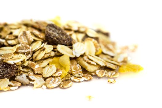 Heap of muesli isolated on white. Delicious granola cereal mix, with dried fruit and seeds.