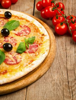 Close up view of pizza with salami, olives and basil