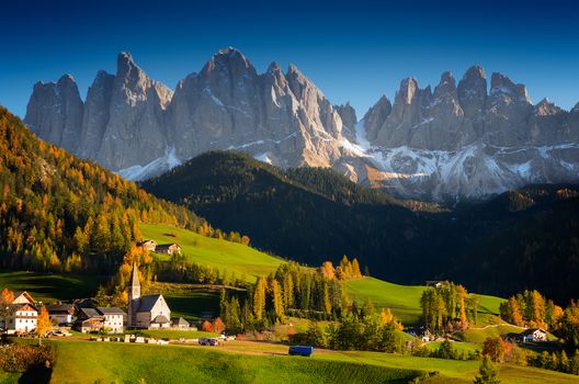 St. Magdalena or Santa Maddalena village with its church in front of the Geisler Dolomites mountain peaks in the Val di Funes Valley (Villnoesstal) in South Tyrol, Italy in autumn.