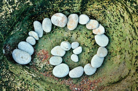 Spiral of pebbles on the stone textures background