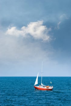 Crimea, the Black Sea. A lone sailboat, and storm clouds.