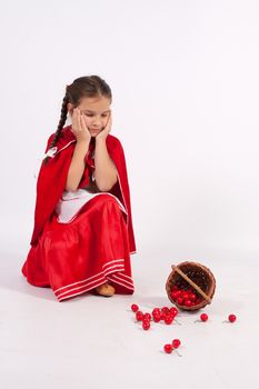 Girl in costume of red cap with spilled cherry,