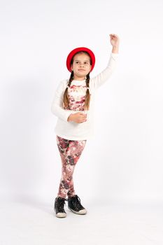 Girl dancing with hands up in red hat