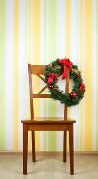 Wooden chair with Christmas decoration on wall background