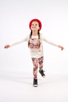 Little girl dance with a red hat with outstretched arms