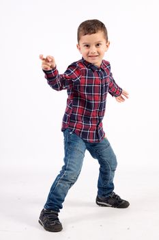 A little boy in checkered shirt, dancing with hands