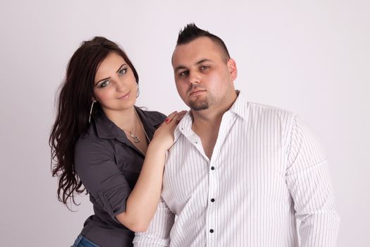 Portrait of long-haired woman rests on the shoulders of a man in a white shirt, looking from himself