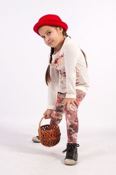 The little girl in a red hat, holding a hand basket