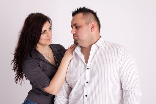 Portrait of long-haired woman rests on the shoulders of a man in a white shirt, looking at each other