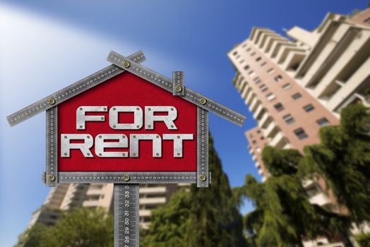 Grey metallic meter ruler in the shape of house with text for rent. For rent real estate sign with tall and blurred buildings in the background