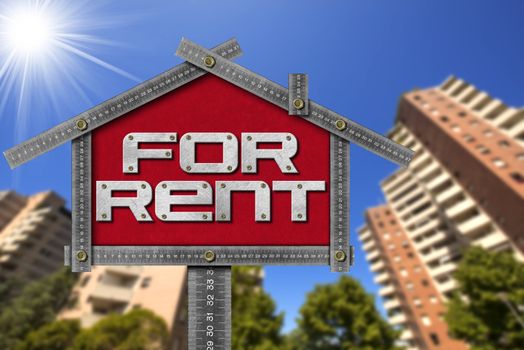 Grey metallic meter ruler in the shape of house with text for rent. For rent real estate sign with tall and blurred buildings in the background