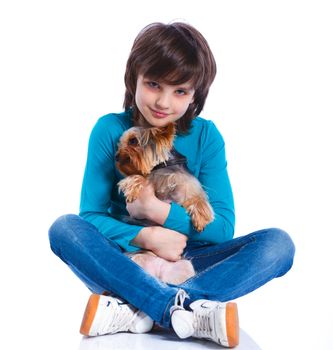 Cute boy sitting with his puppy Yorkshire terrier smiling at camera on white background