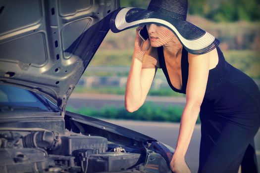 Woman with telephone near the broken car