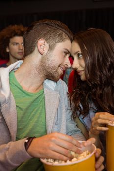 Young couple watching a film at the cinema