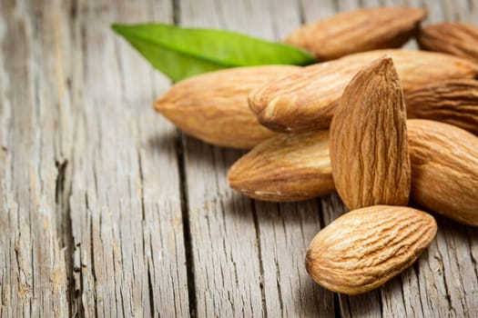 Almonds with leaf on wooden background